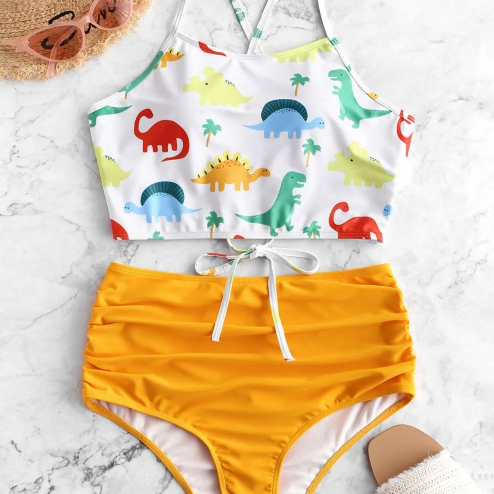 White background with colorful Dinosaur pattern bikini and yellow bottoms